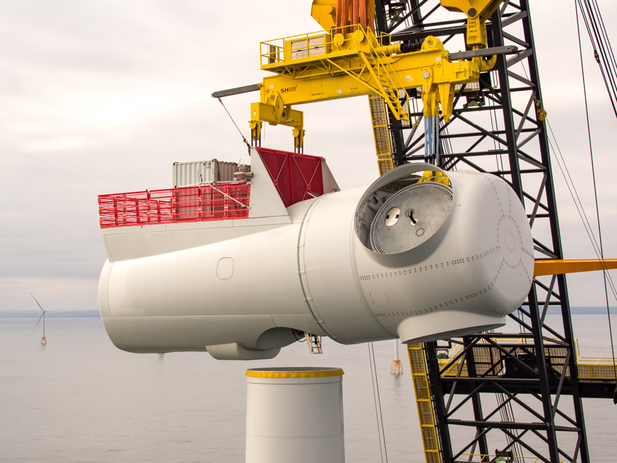 A wind turbine nacelle is being lifted by crane on to a turbine tower at the Beatrice offshore wind farm located off the north east coast of Scotland.
